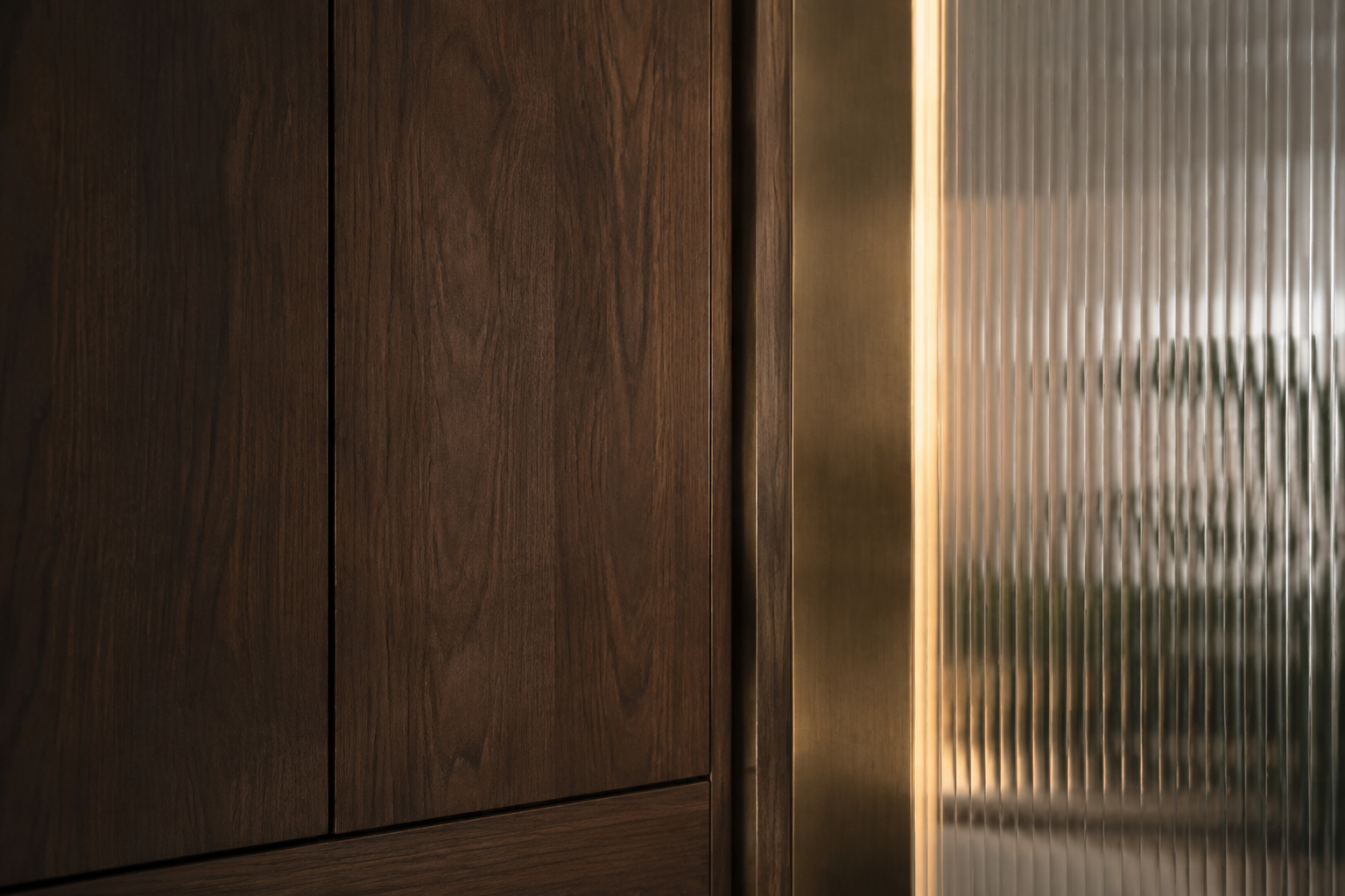 An abstract study of walnut, bronze and fluted glass